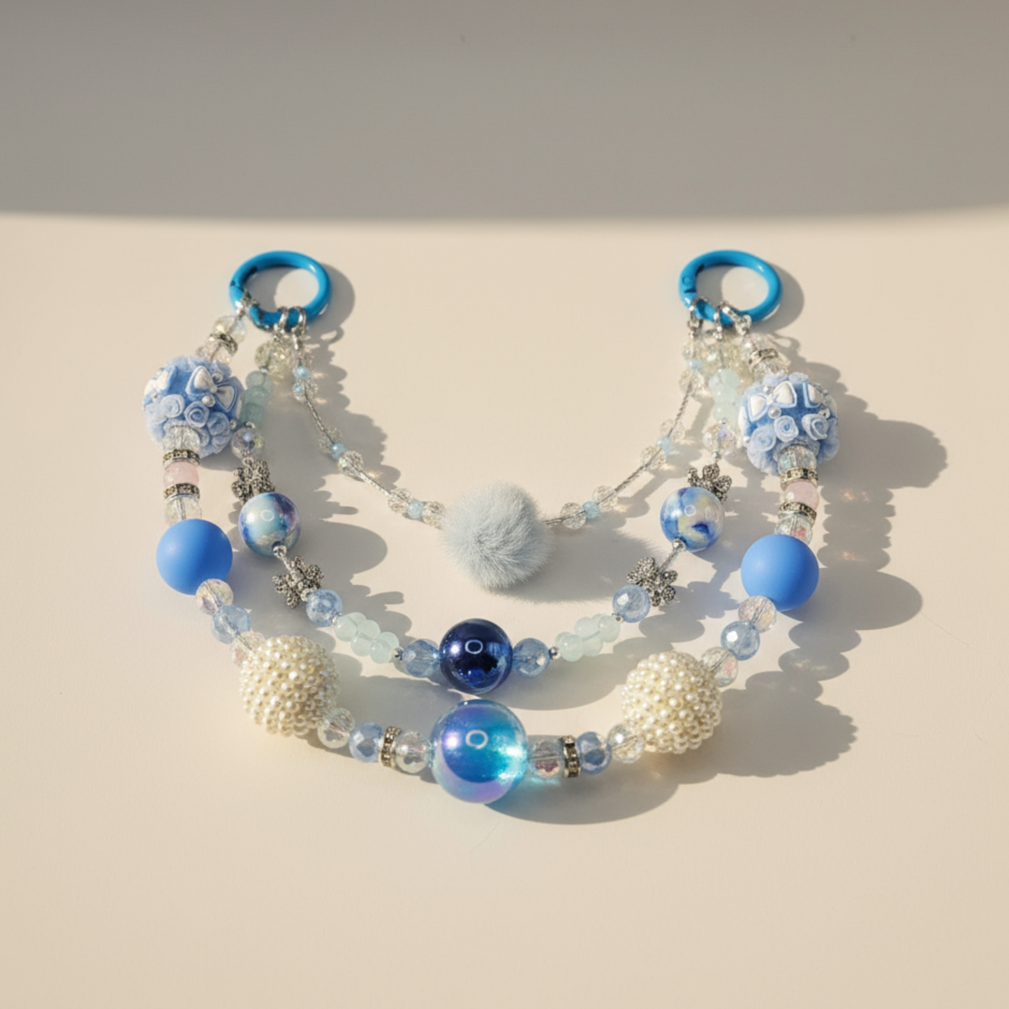 Beaded purse chain with blue and white beads on a beige background