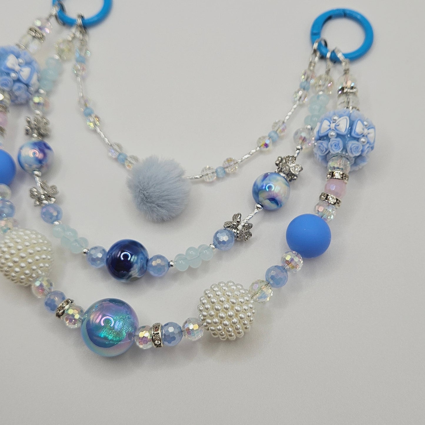 Purse Charm with blue and silver beads on a light gray background