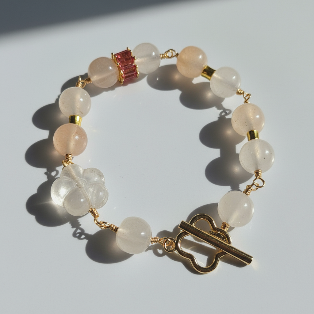 A bracelet with round beads that appear to be clear quartz and golden silk jade, featuring a gold-colored clasp and vacuum plated gold metal.