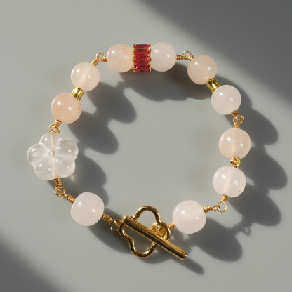 A bracelet with round golden silk jade and clear quartz beads, featuring a gold-colored clasp and gold plating.
