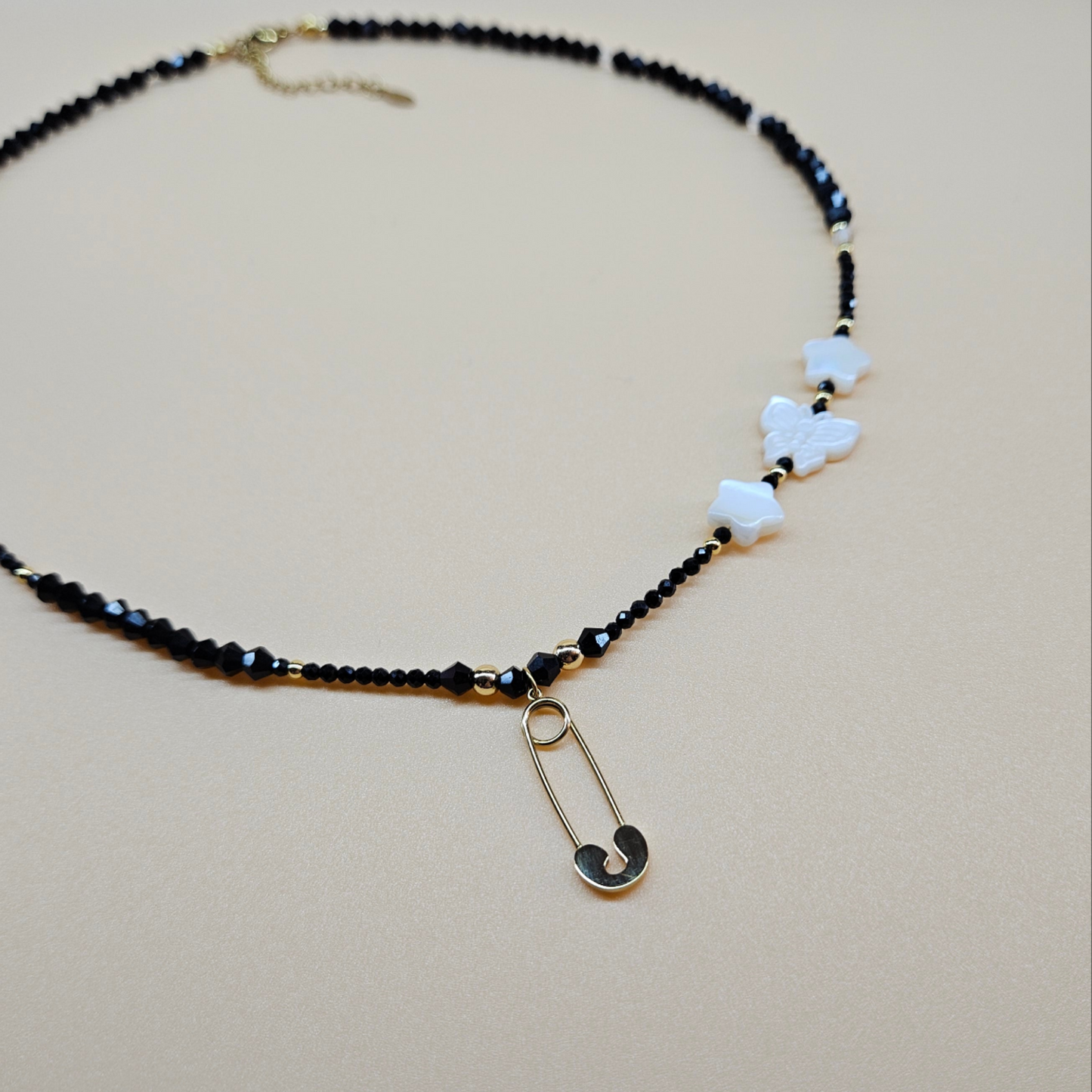 Black Glass Beaded Necklace with Gold-Plated Safety Pin Pendant Featuring Butterfly and Star Shaped Beads