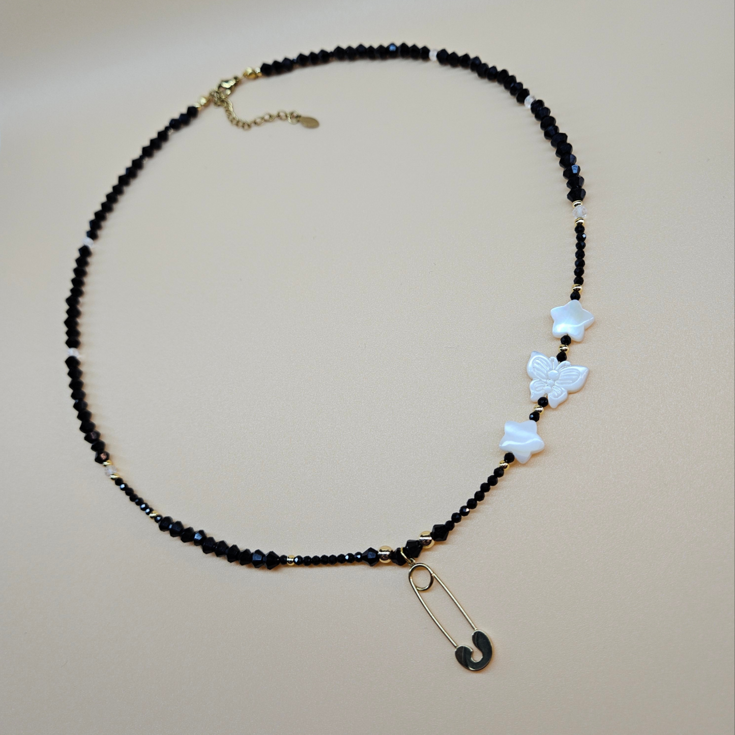 Black Glass Beaded Necklace with Gold-Plated Safety Pin Pendant Featuring Butterfly and Star Shaped Beads