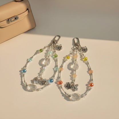 Bag charm with clear quartz and crystal beads on a plain background